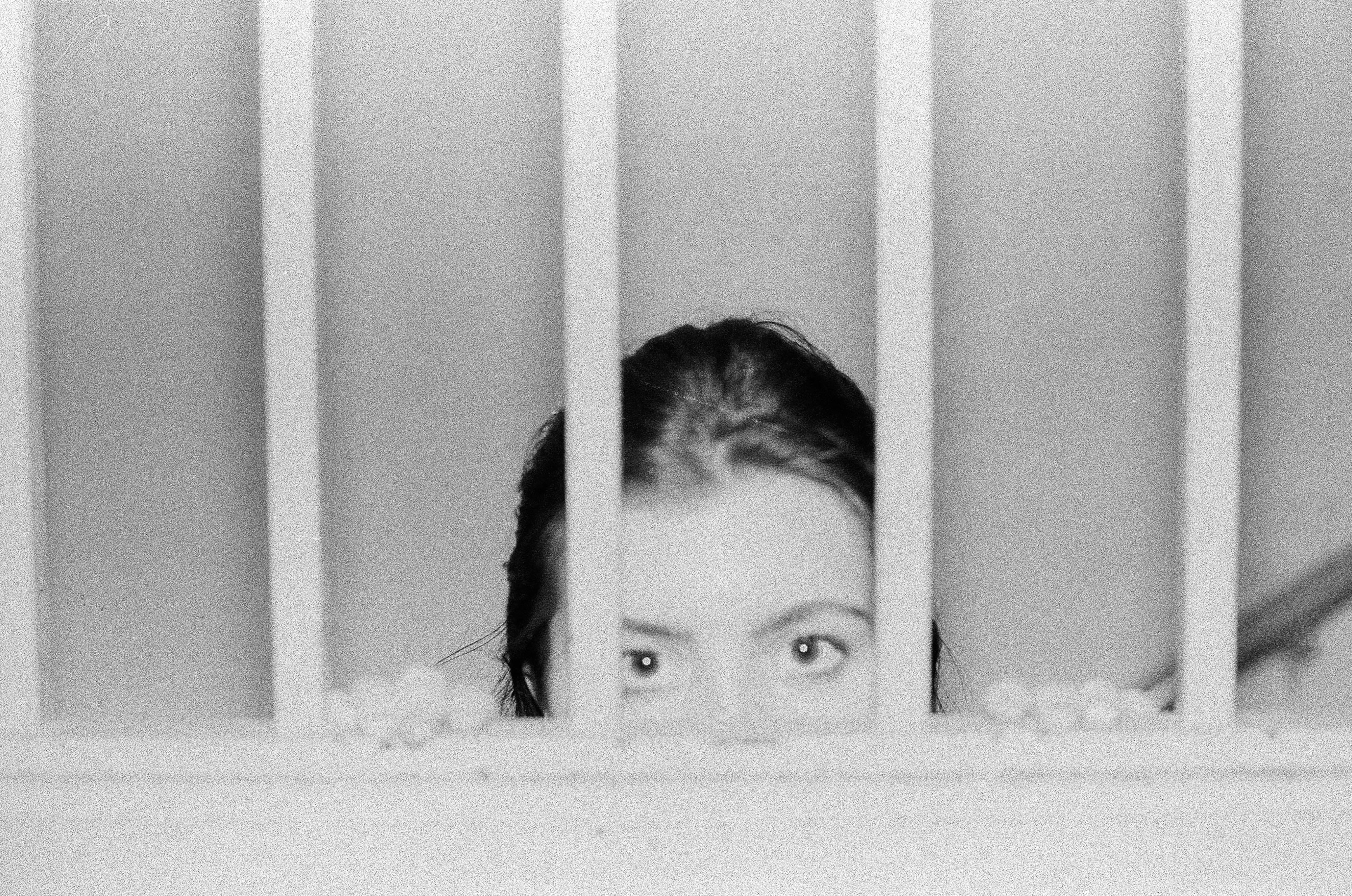Eyes Behind Railing